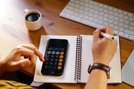 gros-plan-d-un-entrepreneur-travaillant-a-domicile-et-faisant-des-calculs