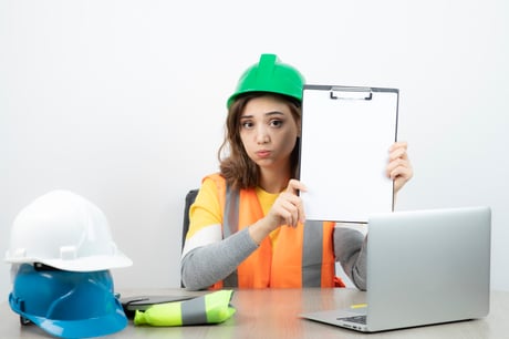 ouvriere-en-uniforme-assise-au-bureau-avec-ordinateur-portable-et-presse-papiers-photo-de-haute-qualite